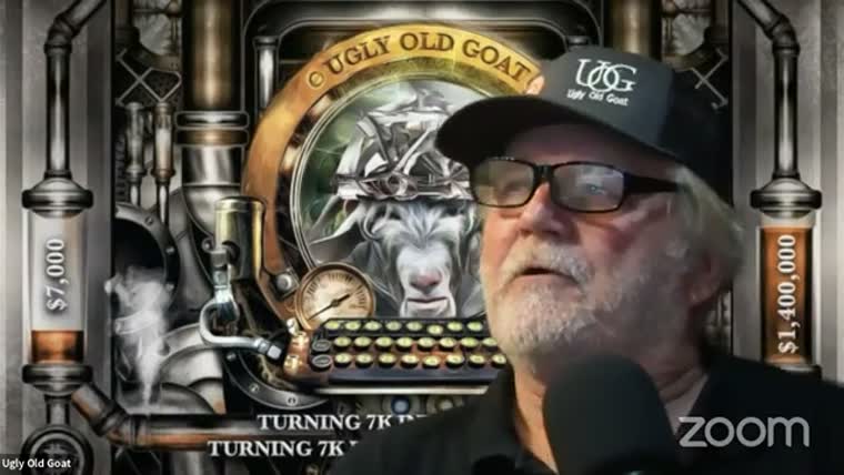 The same man in a cap reading UOG, in front of a painted
         backdrop showing a goat and the words Ugly Old Goat.